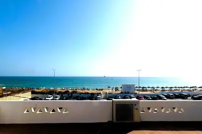a view of a beach with chairs and the ocean at Encanto da Ria in Faro