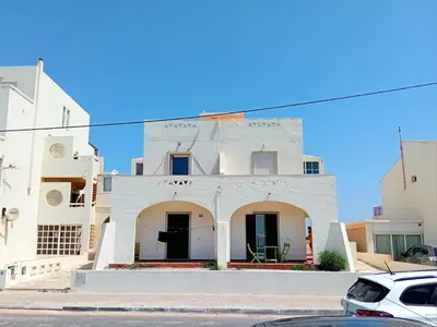 a white building with a car parked in front of it at Encanto da Ria in Faro