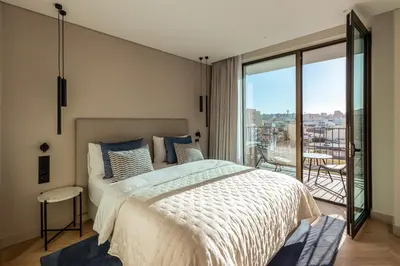 a bedroom with a large bed and a balcony at The View at The Downtown Faro in Faro