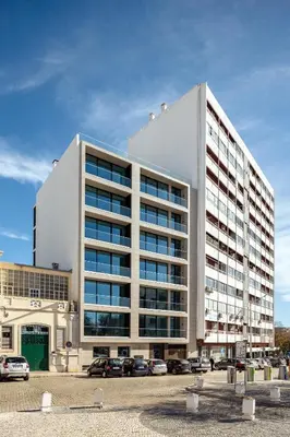 a large white building with cars parked in a parking lot at The View at The Downtown Faro in Faro