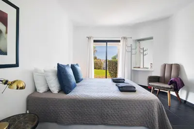a bedroom with a bed with blue pillows on it at Kyara House in Albufeira
