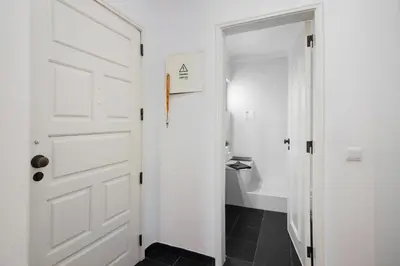 a bathroom with a white door and a black tile floor at Kyara House in Albufeira