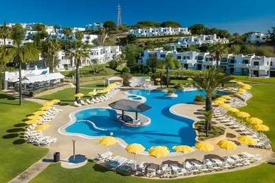 an aerial view of a resort pool with chairs and umbrellas at Kyara House in Albufeira