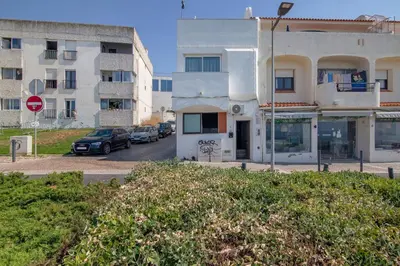 a building with cars parked in a parking lot at Mar à Vista in Albufeira