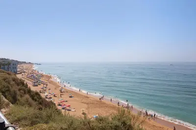 a beach with a bunch of people and the ocean at Mar à Vista in Albufeira