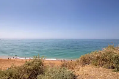 a group of people on a beach near the ocean at Mar à Vista in Albufeira