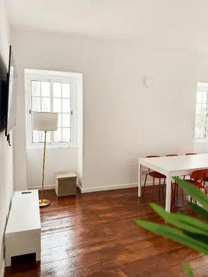 a white room with a table and a lamp at Sao Pedro Guest House in Faro