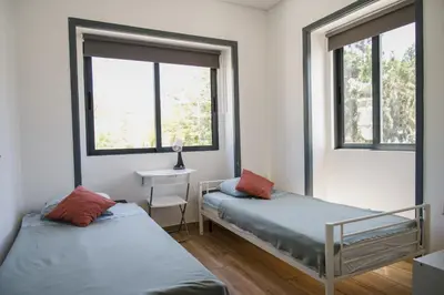 two beds in a room with two windows at Guest House Mercado in Faro