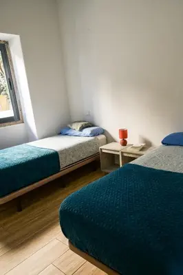 a room with two beds and a table at Guest House Mercado in Faro