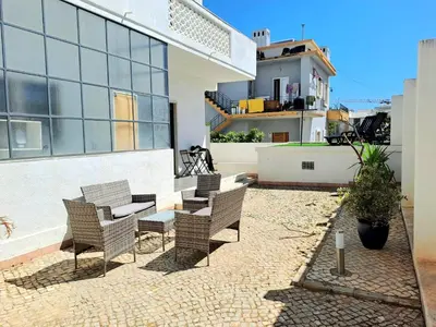 a patio with chairs and a table on a building at Guest House Mercado in Faro