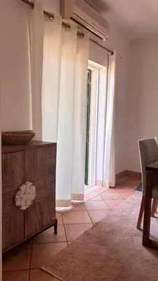 a living room with white curtains and a table at NEW! Casa do Praia Almancil in Almancil