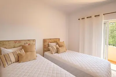 a bedroom with two beds and a window at NEW! Casa do Praia Almancil in Almancil