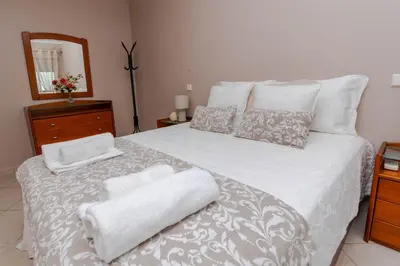 a bedroom with a white bed with towels on it at Ver o Mar in Albufeira