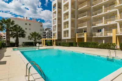 a swimming pool in front of a large apartment building at Ver o Mar in Albufeira