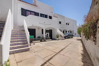 a white building with stairs and a car parked in front at Casa Mar Sol E Sossego in Albufeira