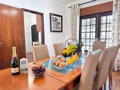 a table with a bowl of fruit and a bottle of wine at Vista Golf by Becherish in Bicas