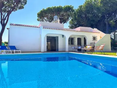 a villa with a swimming pool in front of a house at Vista Golf by Becherish in Bicas