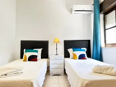 two beds in a room with white walls and blue curtains at Vista Golf by Becherish in Bicas