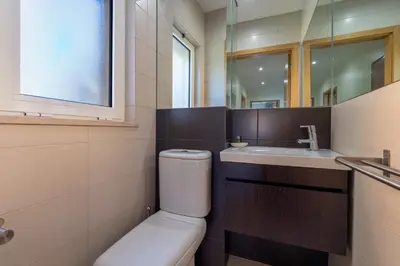 a bathroom with a toilet and a sink and a mirror at Vale Parra Vilage T2 in Guia