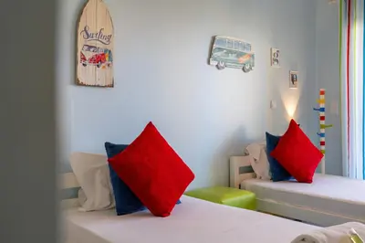 a bedroom with two beds with red pillows and a surfboard at Vale Parra Vilage T2 in Guia