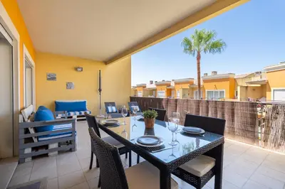 a dining room with a table and chairs on a balcony at Vale Parra Vilage T2 in Guia