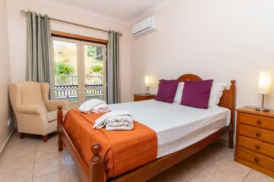 a bedroom with a bed and a chair and a window at Central 2 Beedroms Old Tow Apartment in Albufeira