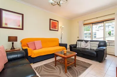 a living room with a couch and a chair at Central 2 Beedroms Old Tow Apartment in Albufeira
