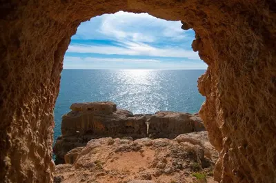 a view of the ocean through a stone cave at Apartment Ouramar - 550 meters from de beach in Albufeira