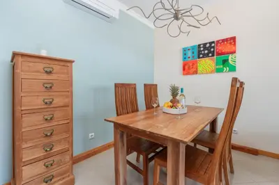 a dining room table with two chairs and a dresser at BnB Homes Eco Apartment with Terrace, 2 Swimming pools & Tennis court in Albufeira