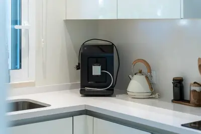 a kitchen with white cabinets and a stove top oven at Apartment Belharucas in Albufeira