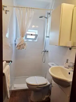 a bathroom with a toilet and a sink and a shower at Casa do Pino in Faro