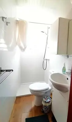 a white bathroom with a toilet and a sink at Casa do Pino in Faro