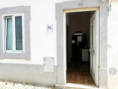 an open door of a white building with the abbreviationadobeadobeadobe at Casa do Pino in Faro