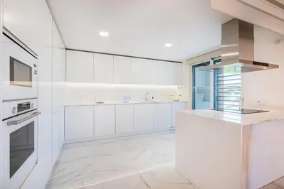 a white kitchen with white cabinets and a stove at Prime Luxury Apartment by Atlantic Places in Albufeira