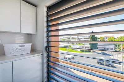 a kitchen with a window with wooden blinds at Prime Luxury Apartment by Atlantic Places in Albufeira