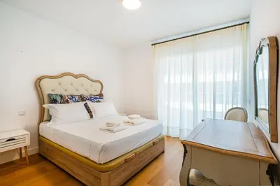 a bedroom with a bed with a desk and a window at Prime Luxury Apartment by Atlantic Places in Albufeira