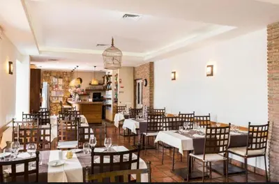 a restaurant with tables and chairs in a room at MyInzu - Club Albufeira Village Garden in Albufeira
