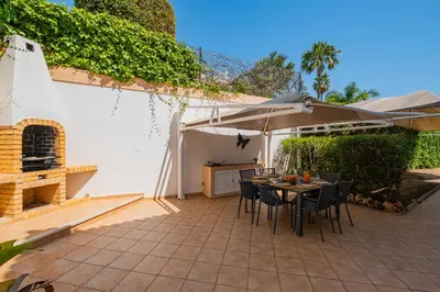 a kitchen with wooden cabinets and a wooden table at Villa Okapi by Atlantic Places in Albufeira