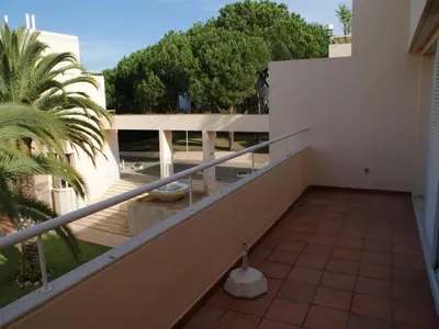 a balcony of a building with a palm tree at Akisol Vilamoura Rise in Quarteira