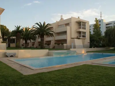 a swimming pool in front of a building at Akisol Vilamoura Rise in Quarteira