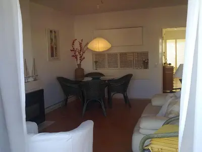 a living room with a table and chairs at Akisol Vilamoura Rise in Quarteira