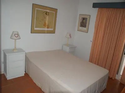 a bedroom with a bed and two night stands with lamps at Akisol Vilamoura Rise in Quarteira