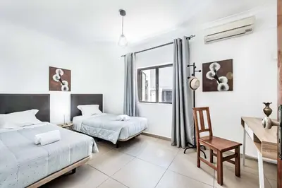 a bedroom with two beds and a desk and a chair at Villa Lela in Galé