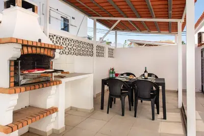 a patio with a table and a fireplace at Villa Lela in Galé