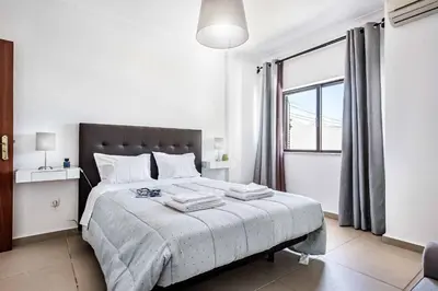 a white bedroom with a large bed and a window at Villa Lela in Galé