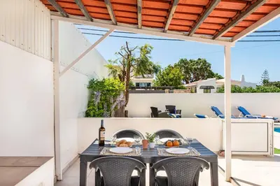 a patio with a table with a bottle of wine at Villa Dela in Galé