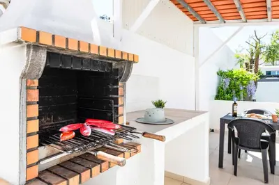 a kitchen with a fireplace with meat on it at Villa Dela in Galé
