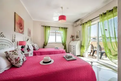 a bedroom with two pink beds with a hat on it at Villa Girassol in Galé