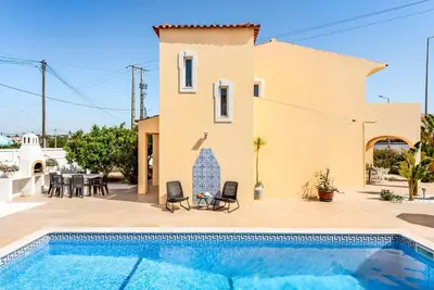 a villa with a swimming pool in front of a house at Villa Girassol in Galé