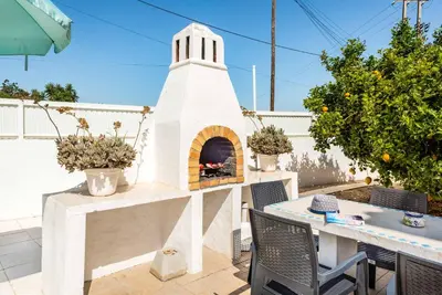 a outdoor pizza oven with a table and chairs at Villa Girassol in Galé